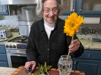 Elderly woman arranging flowers
