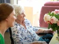 Elderly Lady with Carer Looking at Flowers